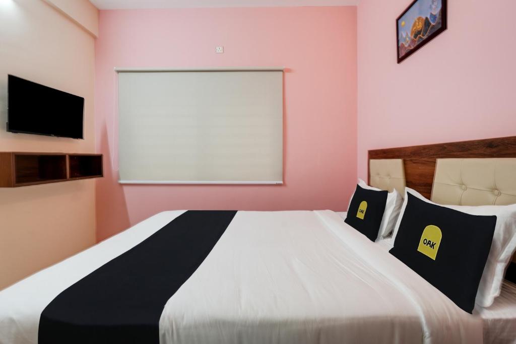 um quarto com uma grande cama branca com almofadas pretas e amarelas em Super Collection O Veritas Grand em Bangalore