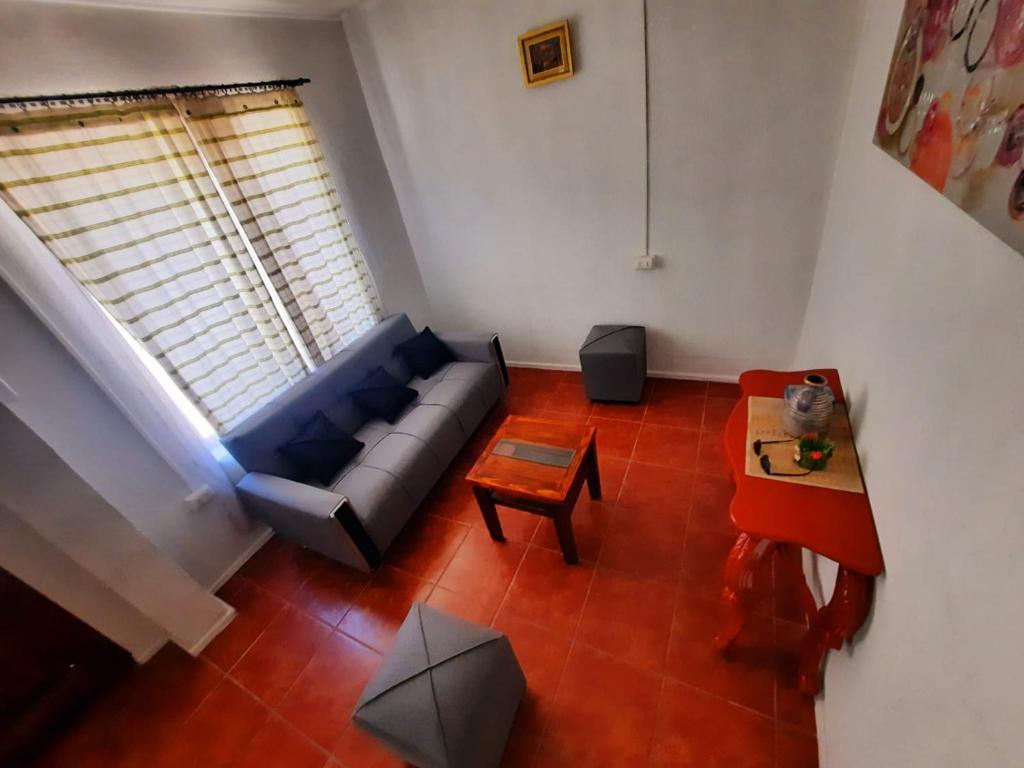 ein Wohnzimmer mit einem blauen Sofa und einem Tisch in der Unterkunft Casa Bellavista Full Equipada in Tomé