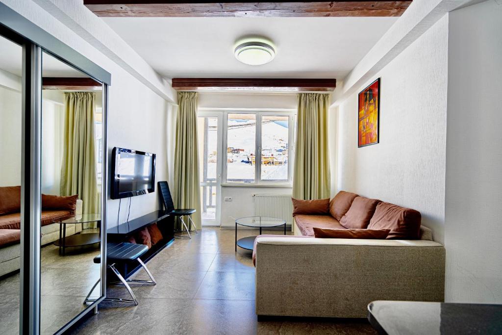 a living room with a couch and a tv at 2-room Apartment Gudauri Penta 703 in Gudauri