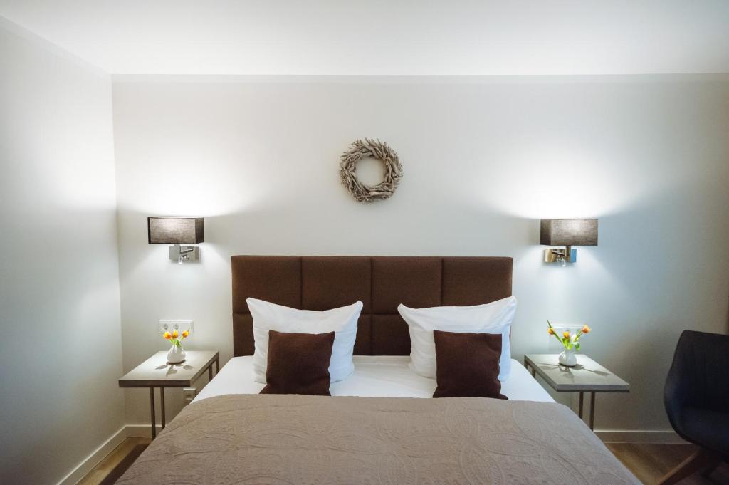 a bedroom with a large bed with two tables at Landhotel Potsdam in Potsdam