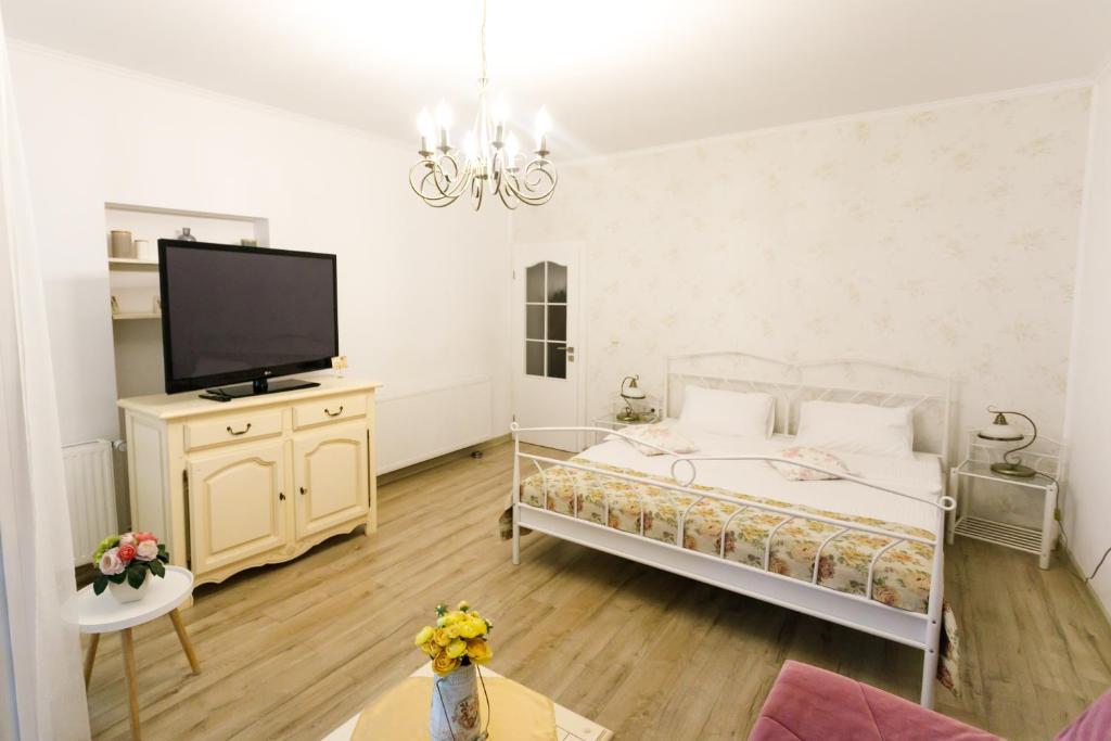 a bedroom with a bed and a flat screen tv at Gong Apartments in Sibiu