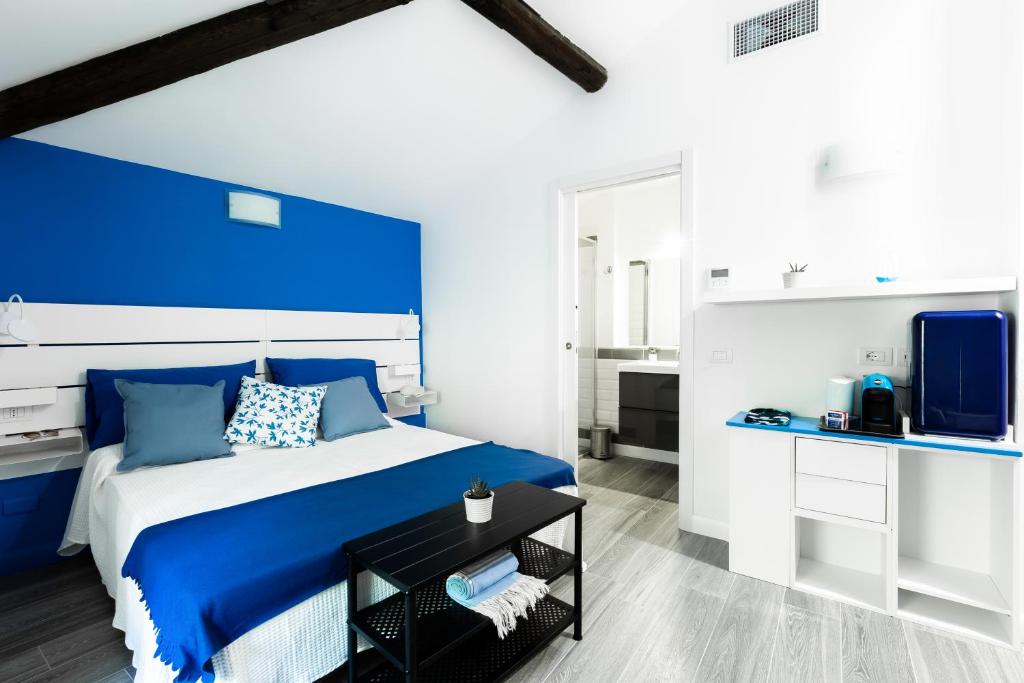 1 dormitorio azul y blanco con 1 cama y TV en Villa Bice, en Bergeggi
