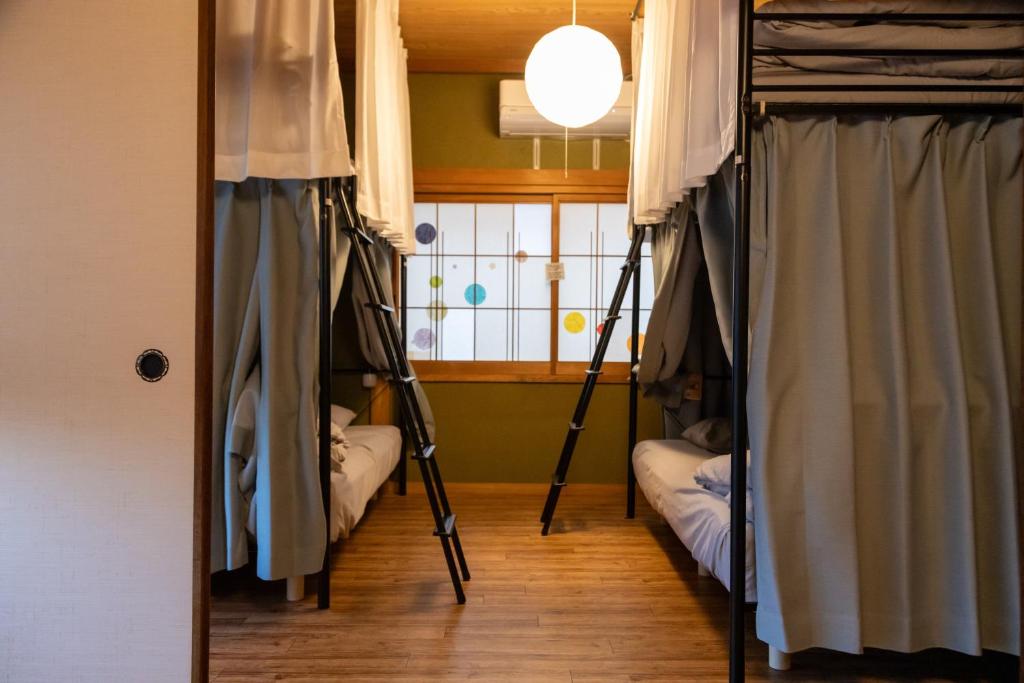 a room with two bunk beds and a window at Dear Uうわじまゲストハウス＆カフェ in Uwajima