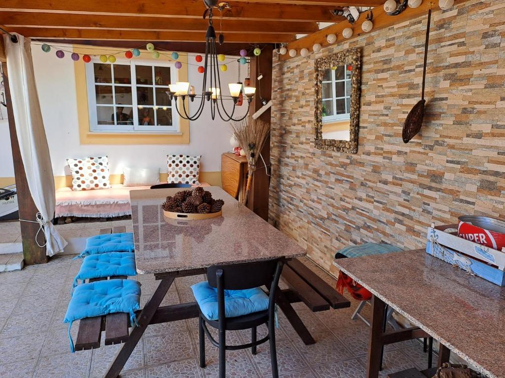 een eetkamer met een tafel en blauwe stoelen bij Peniche House in Atouguia da Baleia