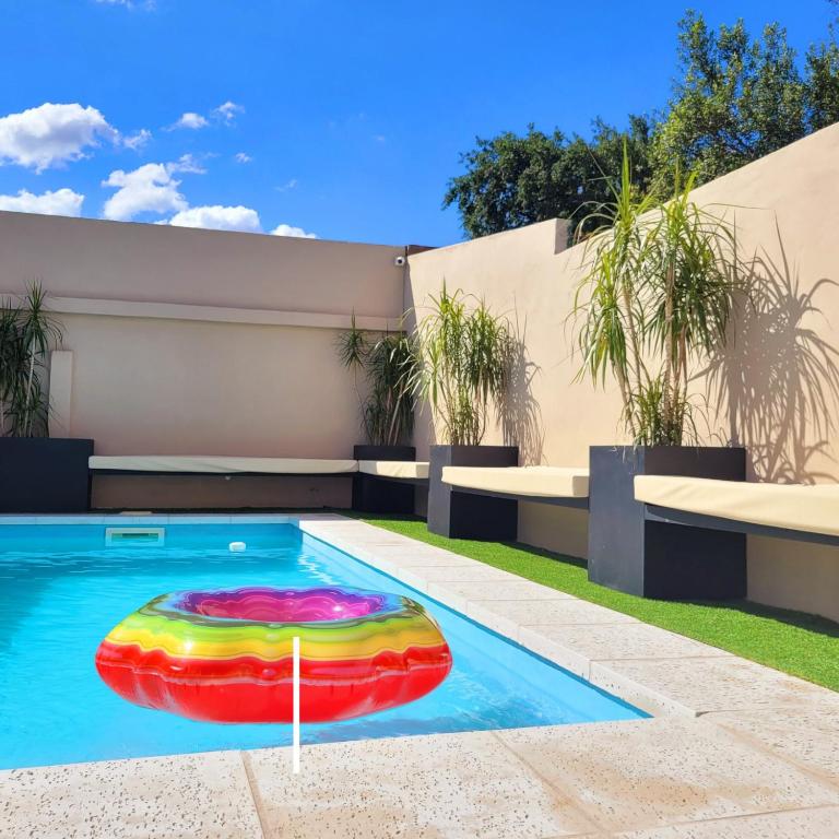a pool with a colorful float in a house at Casa Roque Funes, ubicado en Cerro de las Rosas Córdoba, Ofrece, Asador, Pileta, Cercanias, Estadio Kempes, aeropuerto Ambrosio Taravella, Orfeo Superdomo, Sanatorio Allende, Casa con 2 departamentos individuales y áreas comunes in Córdoba