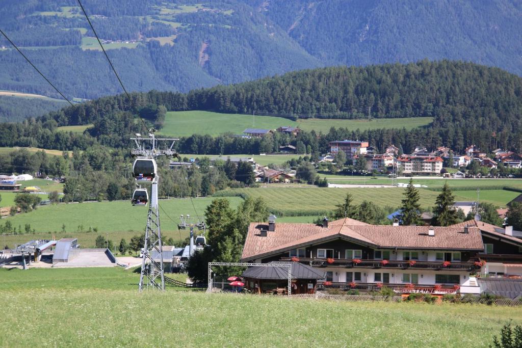a house on a hill with a ski lift at Hotel Heinz in Brunico