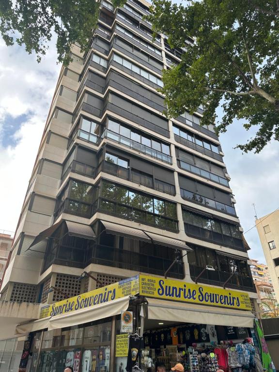 a tall building with a store in front of it at Apartamento las OLAS playa de levante in Benidorm