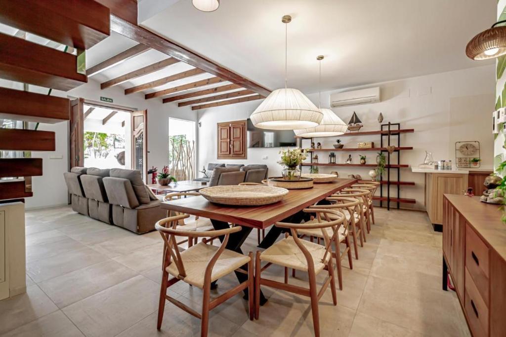Villa JAP في بنيدورم: مطبخ وغرفة طعام مع طاولة وكراسي خشبية كبيرة
