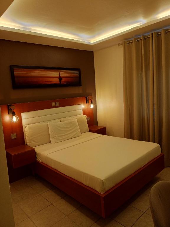 a bedroom with a large bed in a room at First International Inn Downtown in Limbe