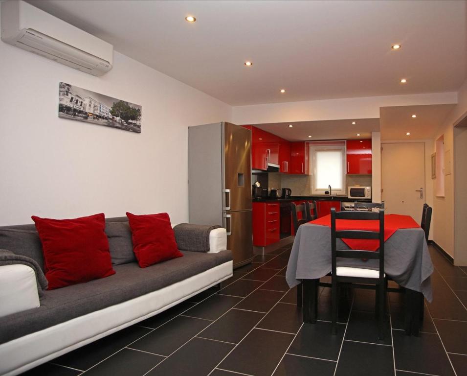 a living room with a couch and a table with red pillows at Geneve Old Town Apartment in Albufeira