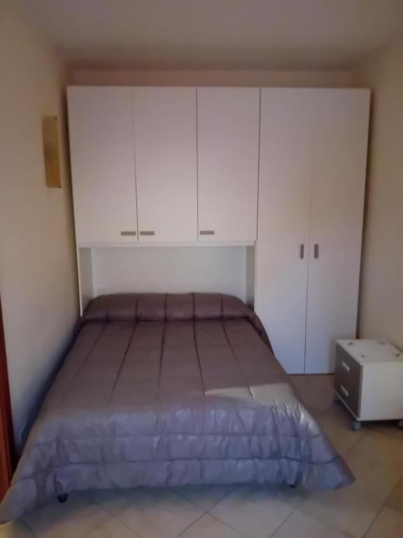 a bed in a room with white cabinets at Casa rosa in Arezzo