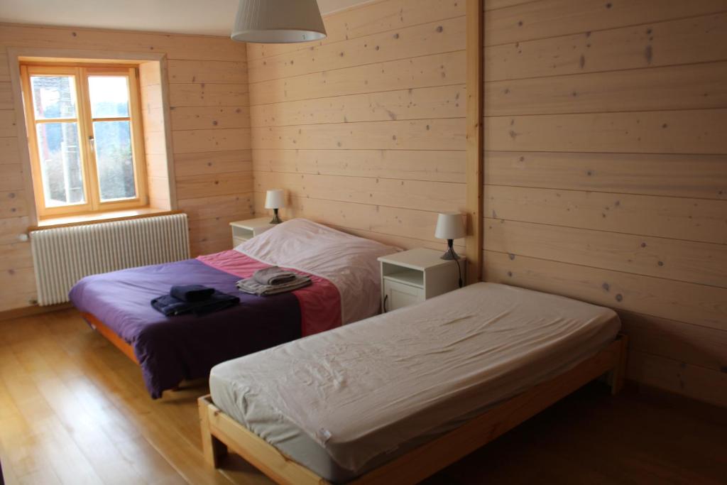 2 camas en una habitación con paredes de madera en Gite le petit Québec 