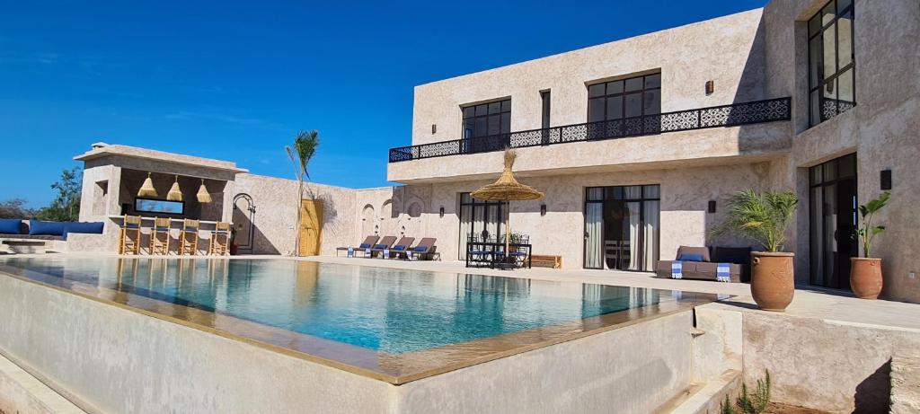 une piscine en face d'un bâtiment dans l'établissement Lalla Essaouira, Villa Najma avec piscine pour 10 personnes, à Essaouira
