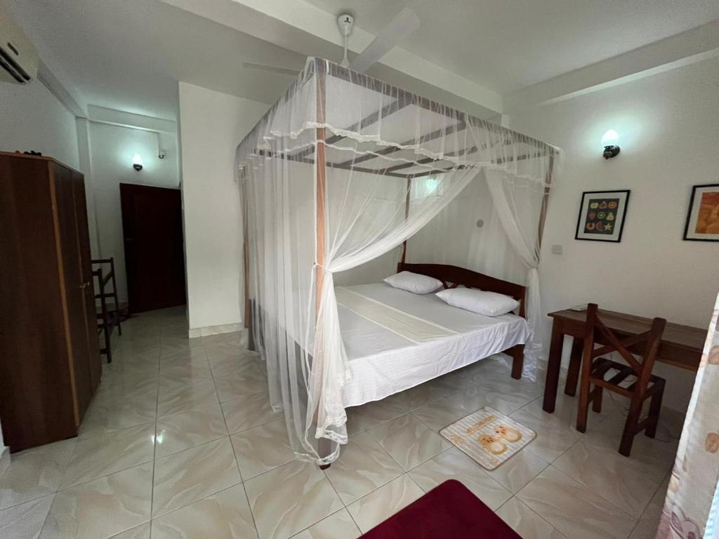 un dormitorio con una cama con dosel en Gangu Guest House Unawatuna, en Unawatuna