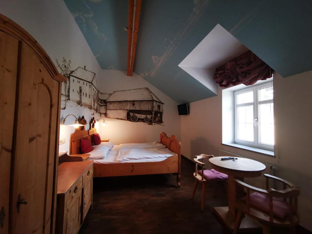 ein Schlafzimmer mit einem Bett und einem Tisch und einem Fenster in der Unterkunft Frühstückspension Wahl in Ruprechtshofen