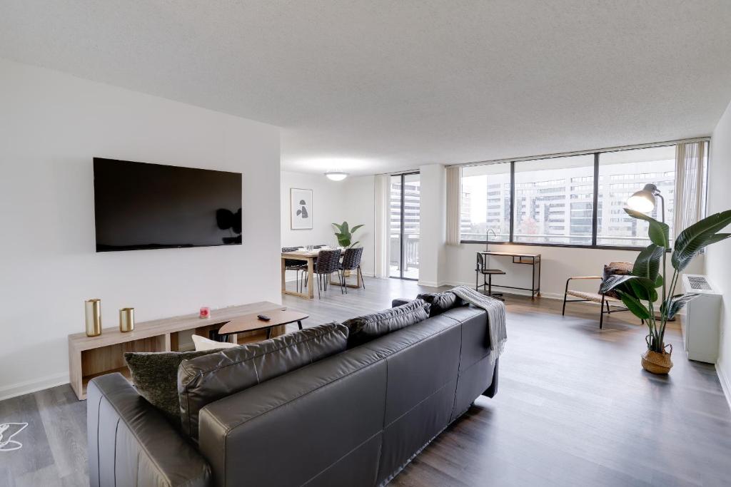 a living room with a couch and a tv at Stay with Style in this Condo at Crystal City in Arlington