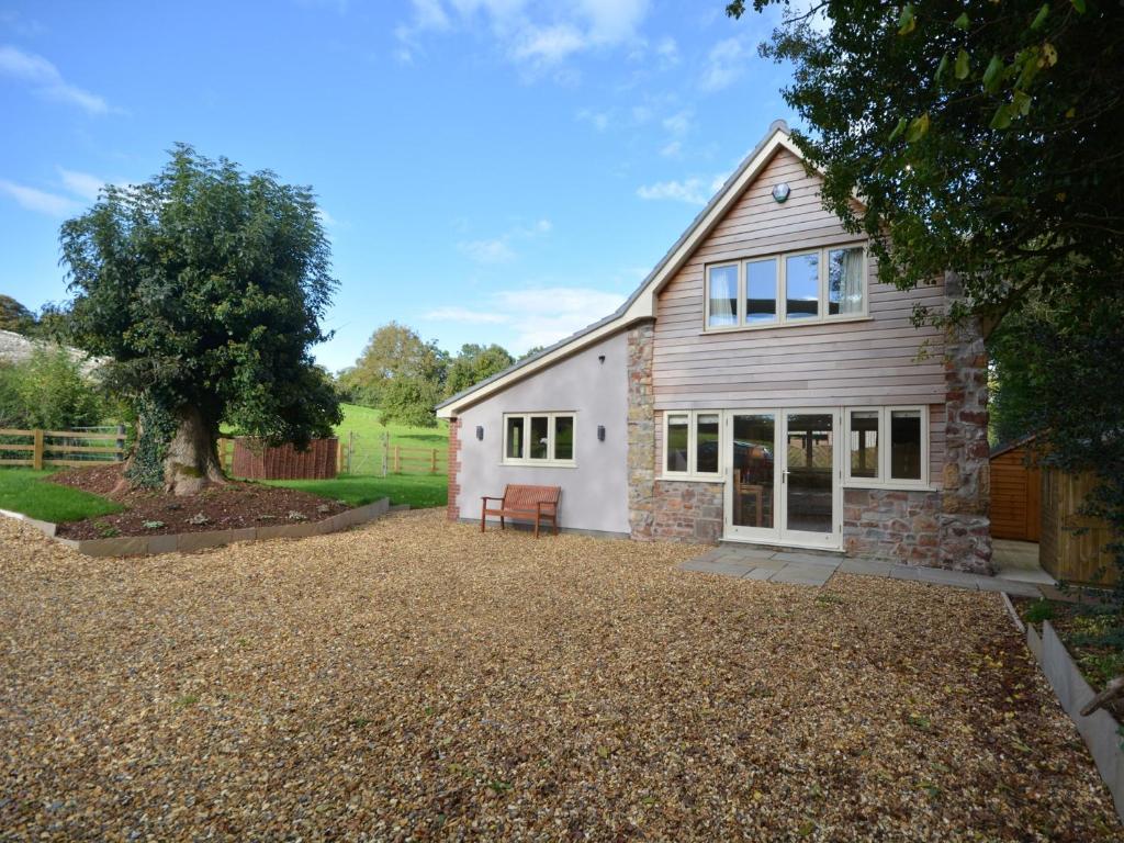 a barn conversion with a gravel driveway and a house at 2 Bed in Bristol 72582 in Winford