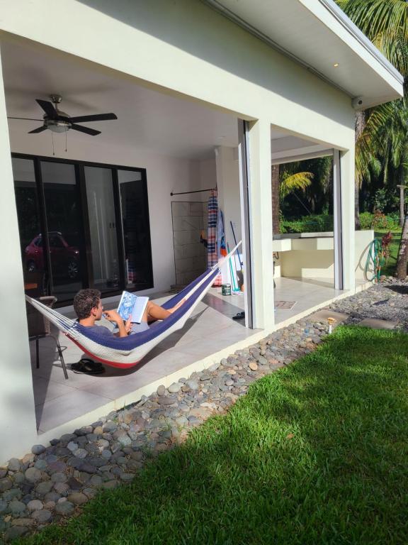 a boy laying in a hammock with a book at Villa Elenita - Sol y Calor ! in Parrita