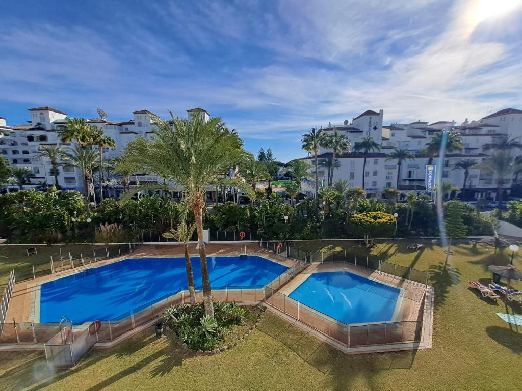 Luxury Apartment in Playas del Duque , Puerto Banus by Holidays & Home في مربلة: اطلالة علوية على مسبح في منتجع