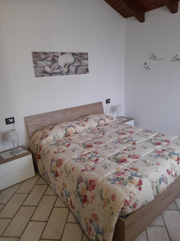 Una cama con edredón en un dormitorio en Malpensa Milano intero appartamento, en Cardano al Campo