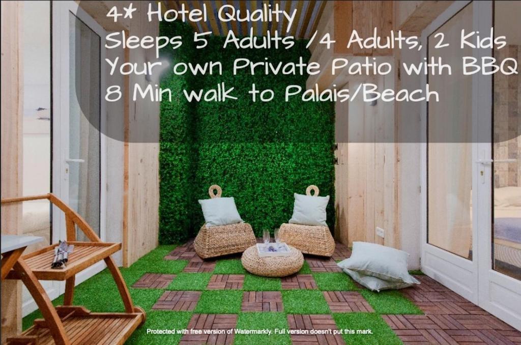 een kamer met 2 stoelen en een groene muur bij Beach Hut * Green oasis with private patio 10 min to Palais & beaches * Pet Friendly in Cannes