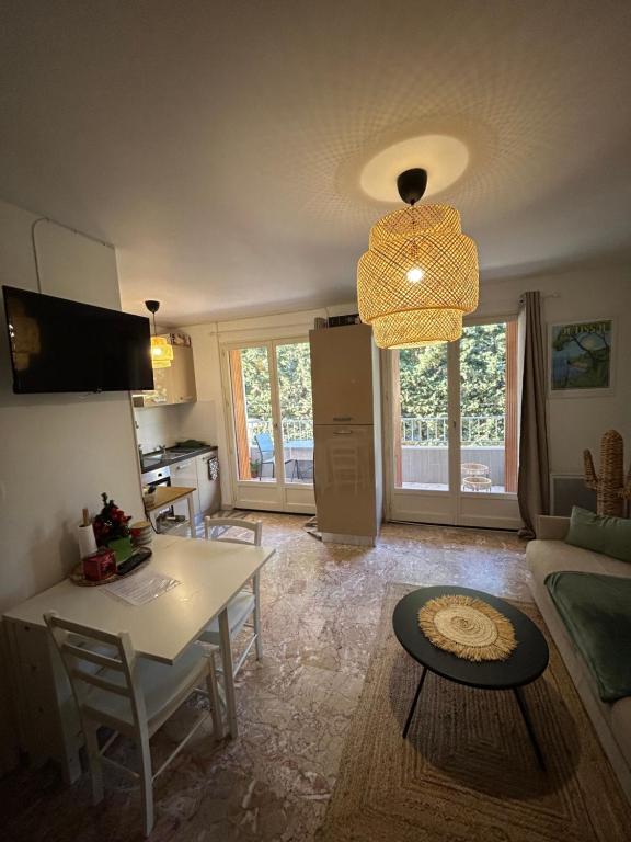 a living room with a table and a kitchen at Petit paradis Portissol 400m plage/commerces in Sanary-sur-Mer