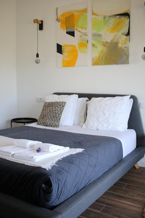 a bedroom with two beds and a painting on the wall at Zambujal Suites in Sesimbra
