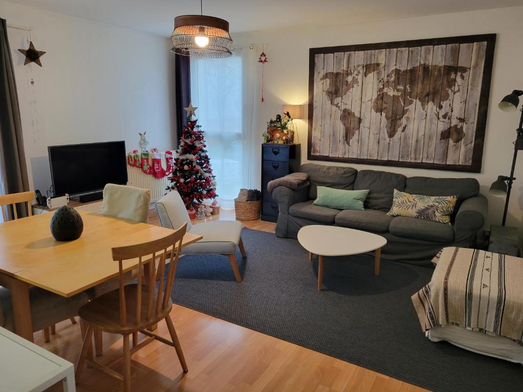 ein Wohnzimmer mit Sofa und Weihnachtsbaum in der Unterkunft JO 2024 -Appartement familial tout confort in Guyancourt