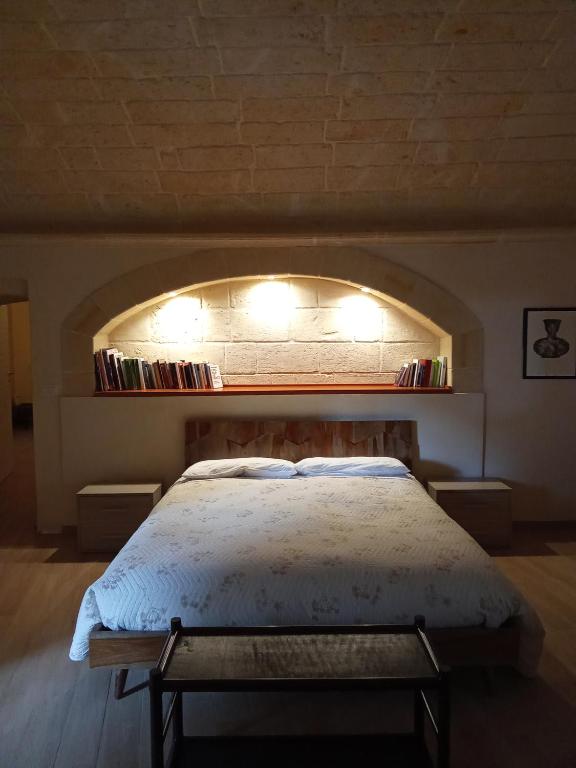 ein Schlafzimmer mit einem Bett mit einem Wandbogen in der Unterkunft CASA NEL QUARTIERE DELLE CERAMICHE in Grottaglie