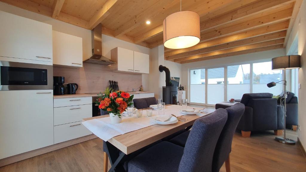 a kitchen with a dining room table with flowers on it at Ferienhäuser Prüm in Prüm