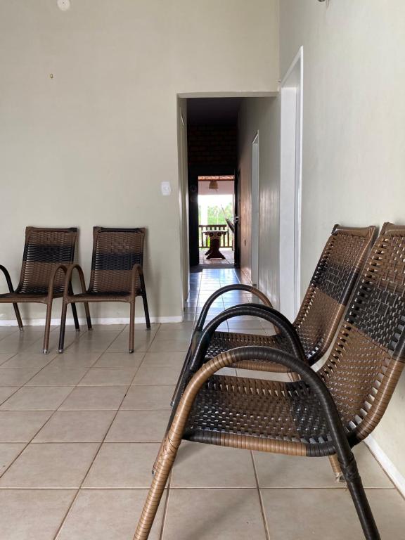 a hallway with three chairs and a table in the distance at Casa Lardeira in Barreirinhas