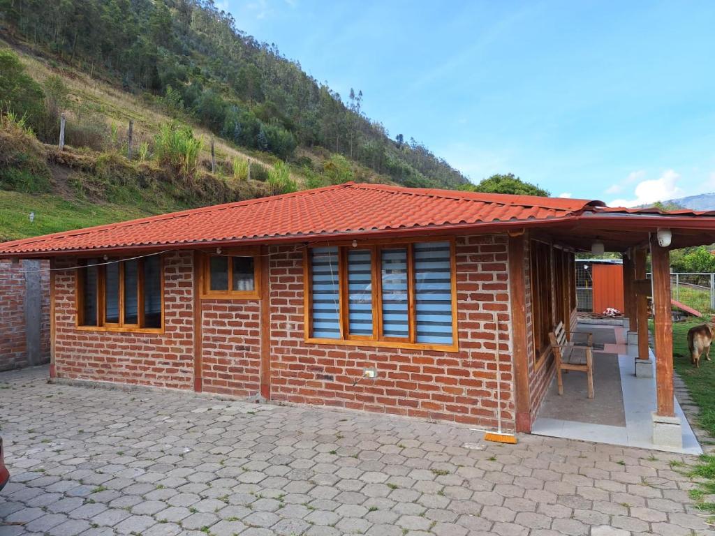 une petite maison en briques avec un toit rouge dans l'établissement Villa Don Alonso: Casa de Campo, à Penipe