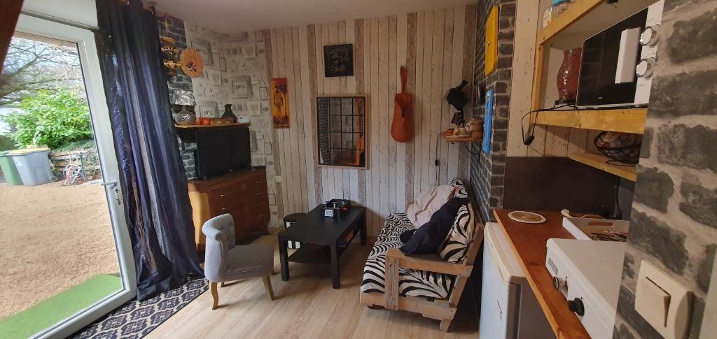 a tiny house with a table and a desk and a room at Guim appart in Guimiliau