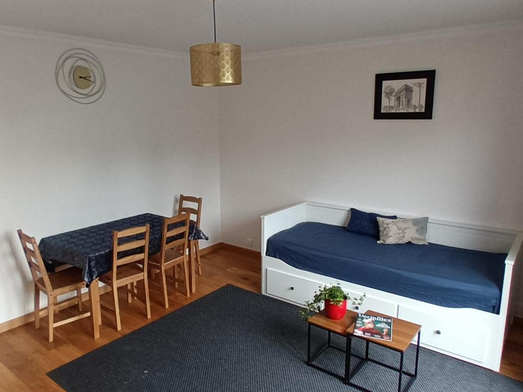 a bedroom with a bed and a table and chairs at Appart à Versailles, 2 à 4 pers, avec parking in Versailles