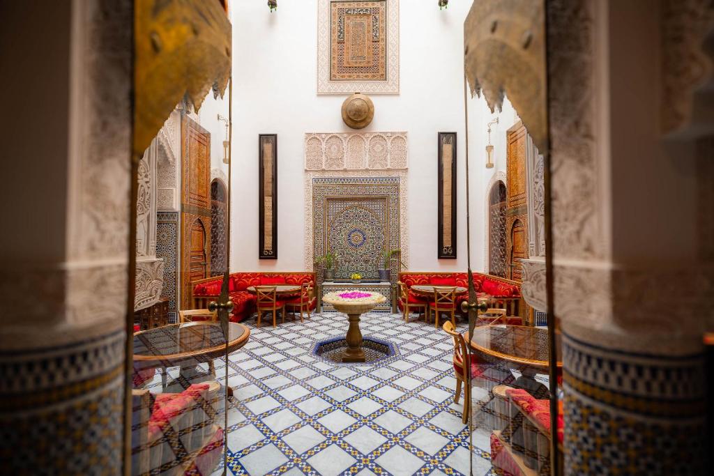 a room with red chairs and a table in a mosque at Riad Mazar in Fez