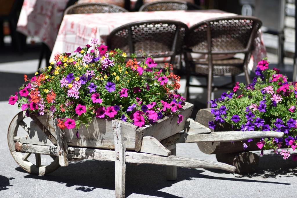a wooden cart filled with lots of colorful flowers at Hotel Les Mélèzes in Haudères