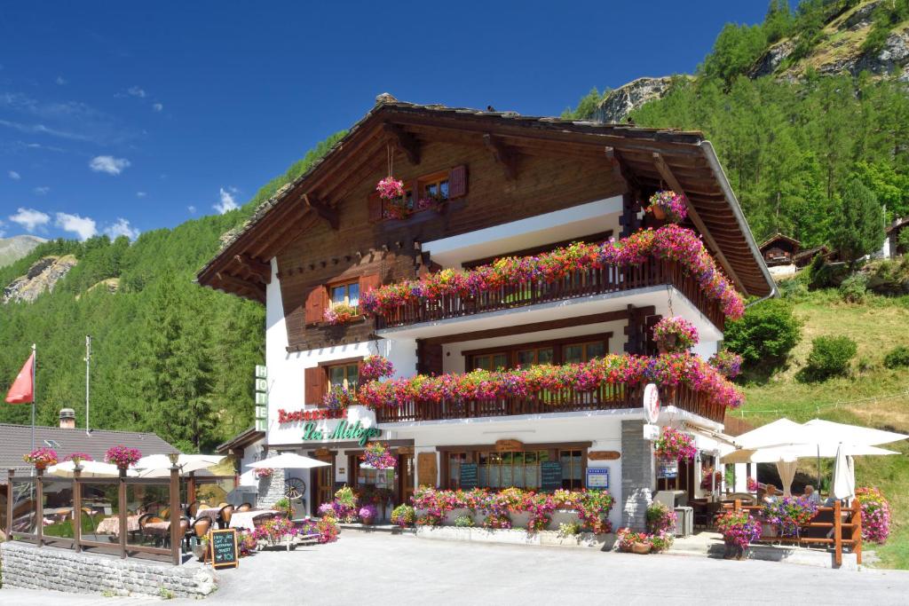 a building with flowers on the side of it at Hotel Les Mélèzes in Haudères