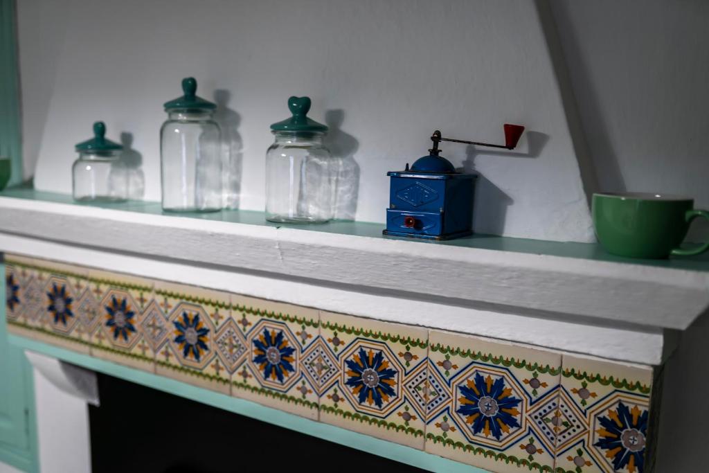 un estante con jarras de cristal encima de una chimenea en Casa Hacha, en Corteconcepción