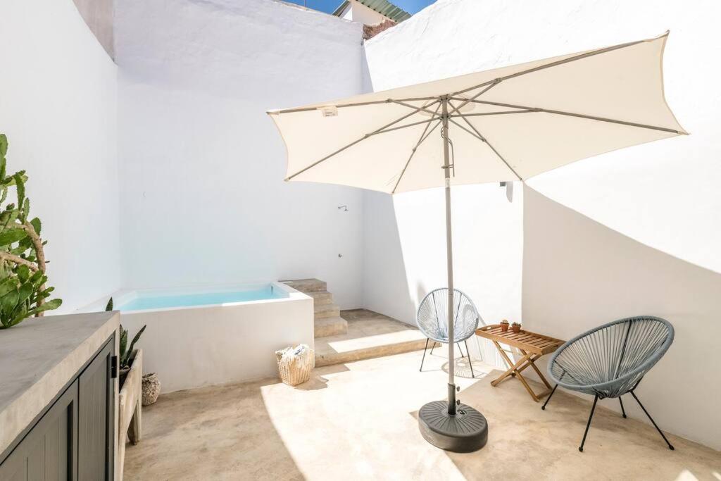 un patio con due sedie e un ombrellone di Traditional house: private pool and sunny terrace a Portimão