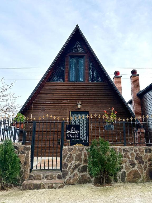 a wooden house with a gate and a fence at Panorama BatumGora in Batumi