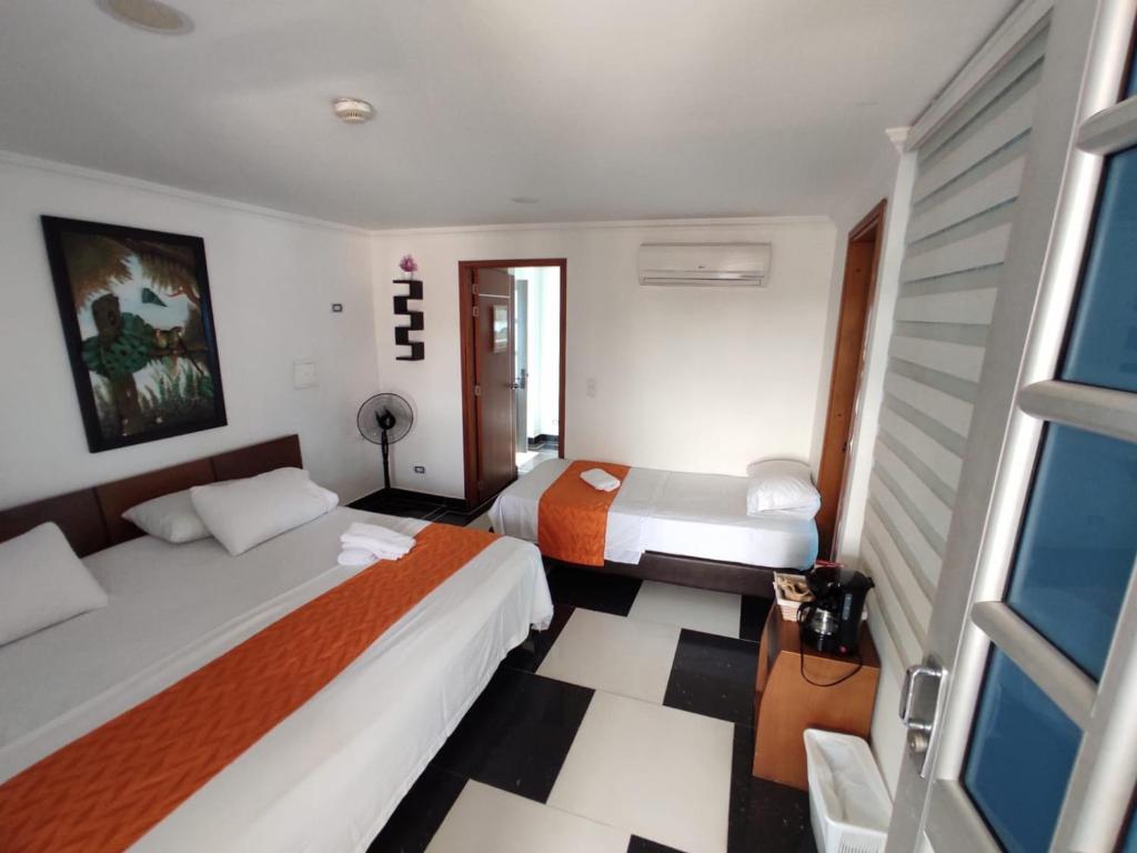 a hotel room with two beds and a window at Apartamento Villa llano in Villavicencio
