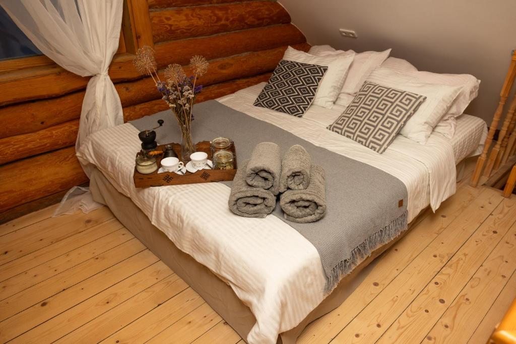Una cama con toallas y una bandeja de donuts. en Jaunlidumnieki, en Mālpils