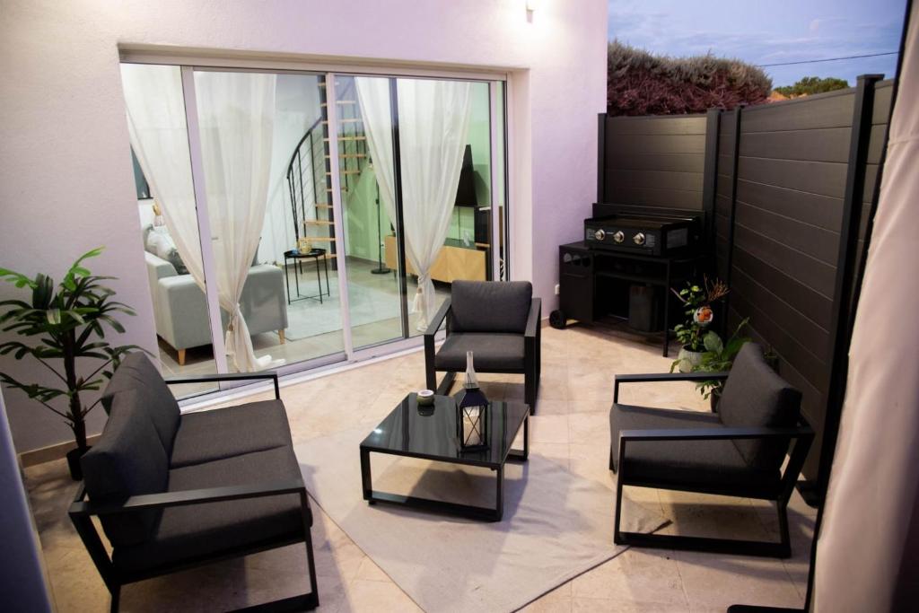 un soggiorno con sedie e tavolo di Les Brézines - Maison Clim Terrasse Plancha au coeur de Mus 3 Etoiles - MaisoncarréeConciergerie a Mus