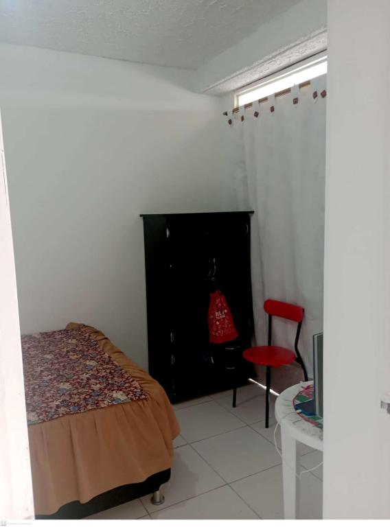 - une chambre avec un lit et une chaise rouge dans l'établissement Habitación Privada, Br. El Nogal Armenia Quindío, Colombia, à Armenia