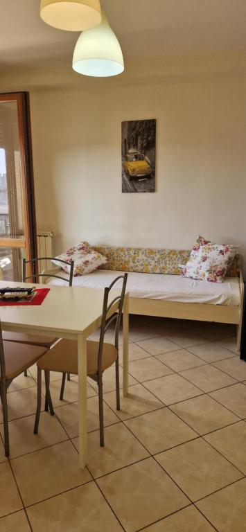 Cette chambre comprend un lit, une table et des chaises. dans l'établissement Bilocale via Rimini 5C, à Pomezia