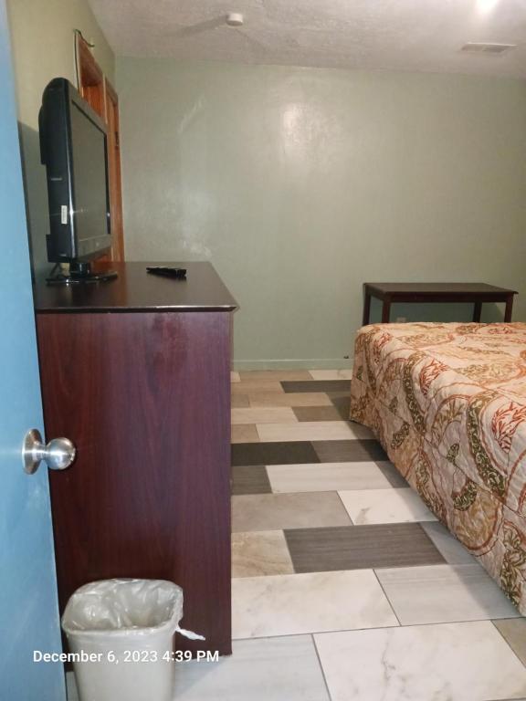 a hotel room with a bed and a flat screen tv at Travelers Inn Beaver 