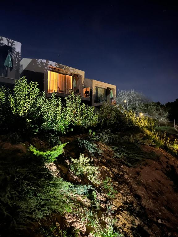 a house on top of a hill at night at Zambujal Suites in Sesimbra