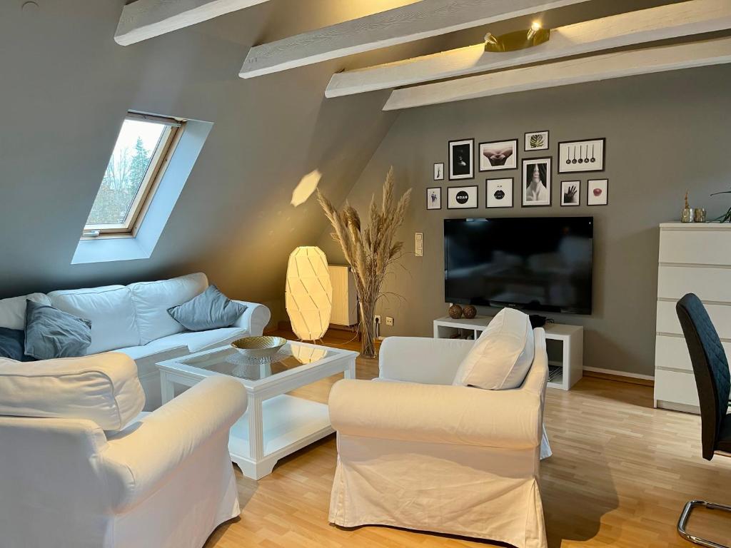 Riverview Loft in Central Herzogenaurach في هيرتسوجيناوراخ: غرفة معيشة بأثاث أبيض وتلفزيون بشاشة مسطحة