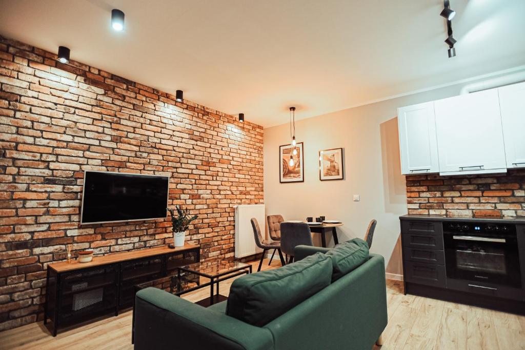 a living room with a couch and a brick wall at LOFT Luxury Apartment & Parking in Leszno