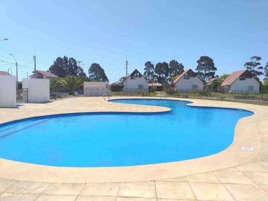 a large blue swimming pool in a yard at Casa Condominio en Tongoy cercano a puerto Velero in Tongoy